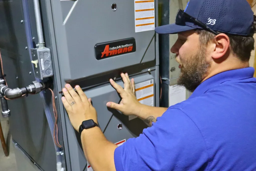 Midwest Comfort tech installing Amana condenser