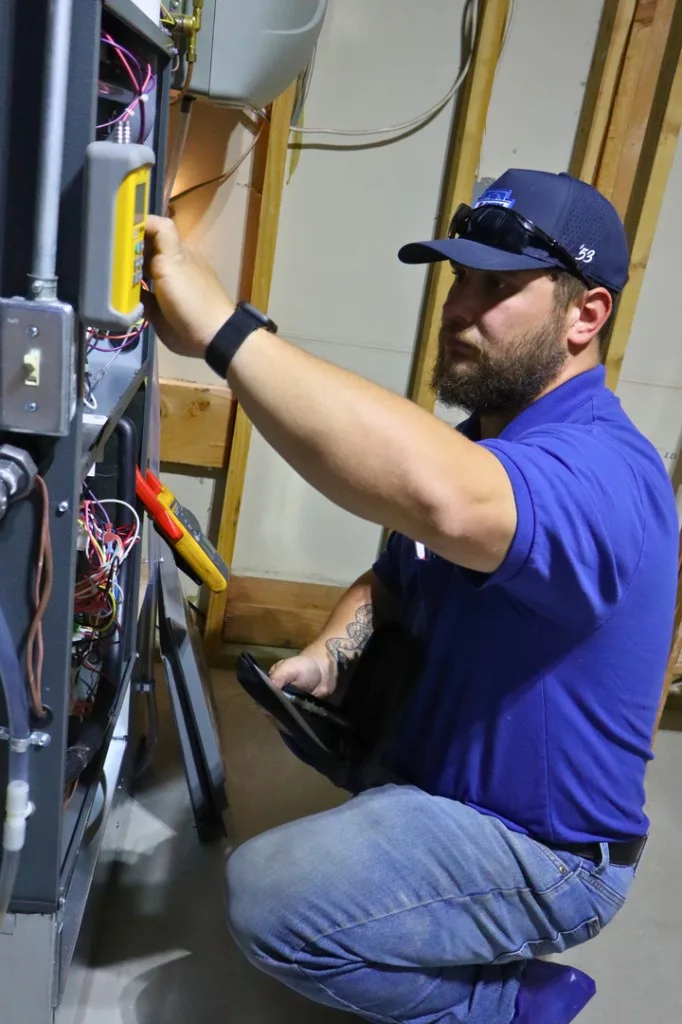 Tech diagnosing an HVAC system with a multimeter